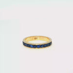 Load and play video in Gallery viewer, Yellow Gold Eternity Ring with Deep Blue Round Sapphire